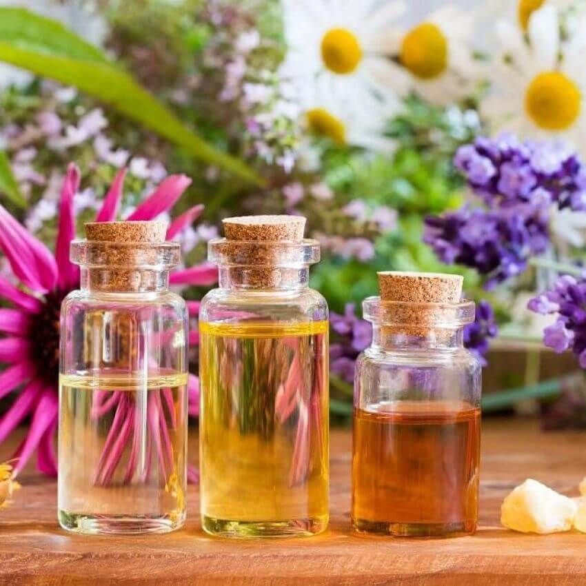 Essential oil bottles with flowers for blog - NATURAL BUG REPELLENT IDEAS TO CONQUER SUMMER