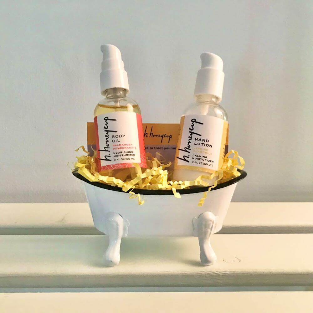 body oil and hand lotion in white metal bathtub
