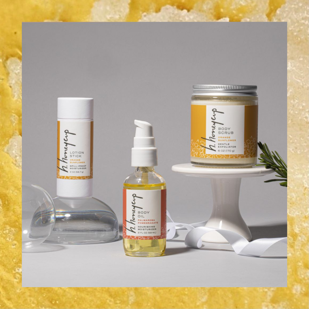 H. Honeycup three flagship products staged at different levels: lotion stick, body oil, orange scrub