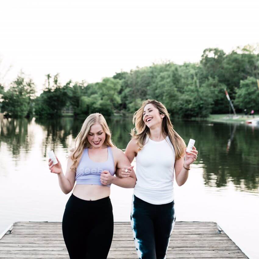  Two women having fun at a dock on lake carrying skincare for blog: SKINCARE VIBES: LOOK GOOD, FEEL GOOD, PLAY GOOD