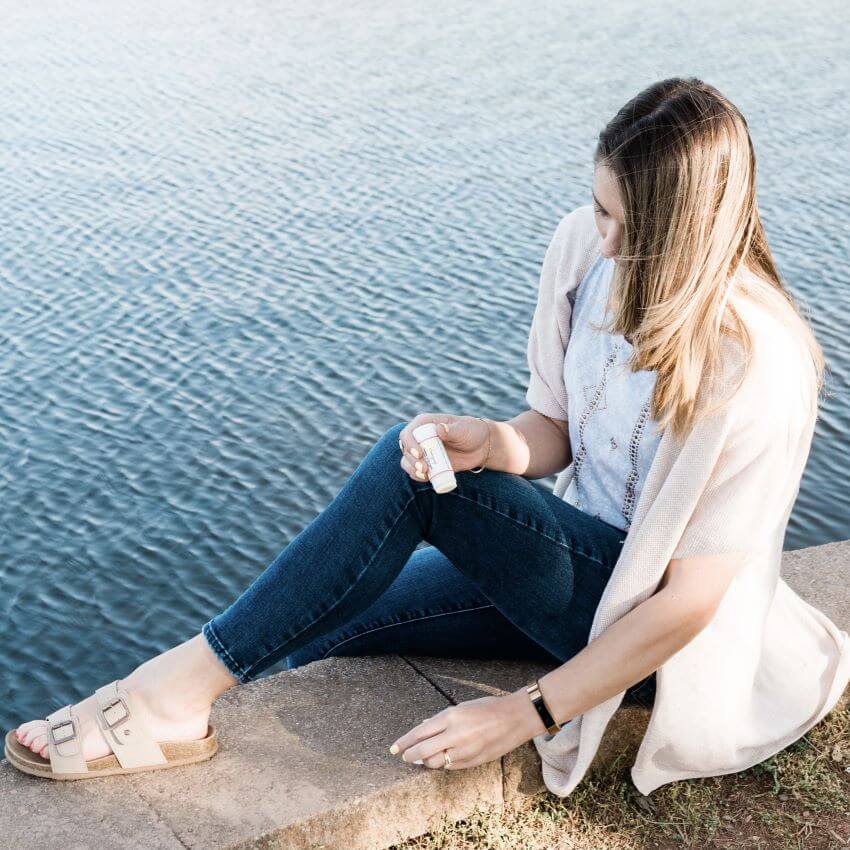 Woman sitting by a lake for blog: CHOOSING THE RIGHT NATURAL BEAUTY BRAND