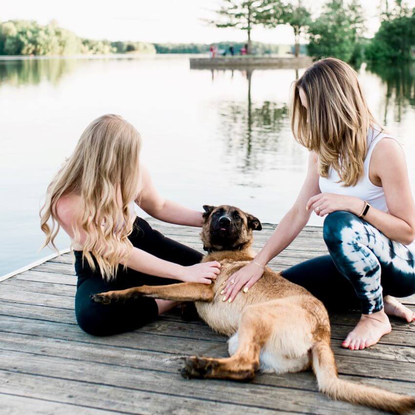 Two women at a lake petting a dog for blog: VEGAN, PLANT-BASED, CRUELTY-FREE SKINCARE: WHAT IT ALL MEANS
