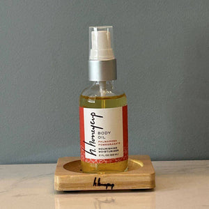 body oil resting on bamboo soap dish