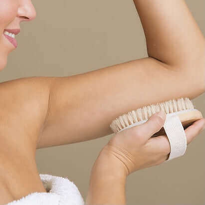 woman using dry brush on arm