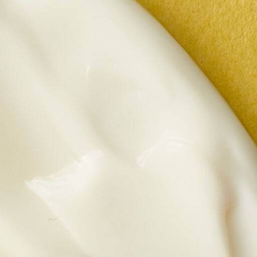 Creamy lotion texture on yellow background