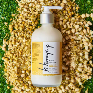 Body lotion shown with chamomile on grass